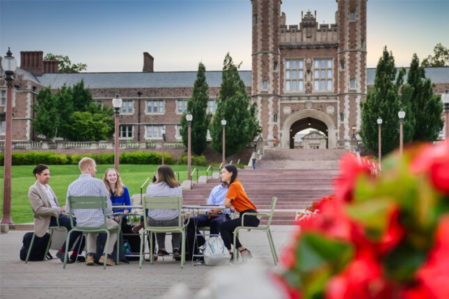 Group of people sitting around table in Tisch Park with Brookings in background